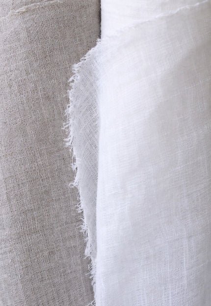 Two rolls of fabric, one gray and one white, on a gray background.